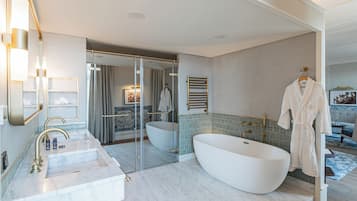 A modern bathroom with a freestanding bathtub, a large mirror, and a walk-in shower.