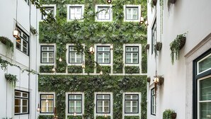 A multi-level atrium with a green wall garden, hanging lights, and a restaurant named FEDERICO.
