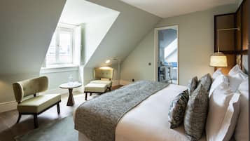 Una habitación de hotel con cama, una silla, una mesita y una ventana.