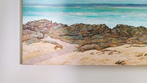 Una pintura de una escena de playa con rocas y agua.