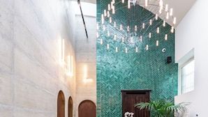 A modern interior with a wooden staircase, glass railings, and a green herringbone-patterned wall. - Vico Milano (Milan)