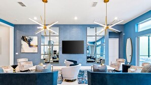 A modern living room with blue walls, two large sofas, a TV, and a large window.
