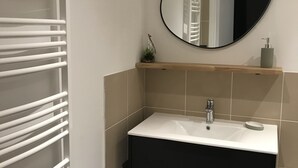 A bathroom with a white sink, black cabinet, and a mirror above it. - 4-6 Pers apartment in the heart of the Chartreuse at the foot of the ski slopes (Sarcenas)