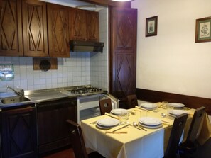 Kitchen area with stove, sink, and dining table for four.