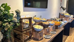 Un buffet proposant une variété de plats et agrémenté d’une plante décorative.