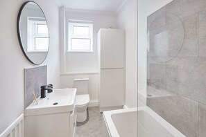 Bathtub, hair dryer, towels, shampoo