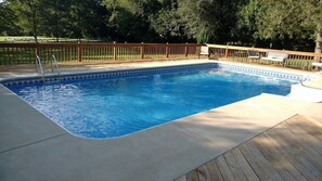 A rectangular swimming pool with a wooden deck and a metal ladder. - Ticky's Cottage at Empire Estate (Lebanon)