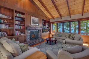A cozy living room with a fireplace, bookshelves, and a sofa.