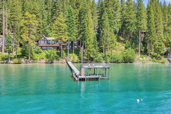 A lakeside property with a dock extending into the water, surrounded by dense forest. - Sunrise by Sunnyside - Lakefront - TLUXP (Tahoe City)