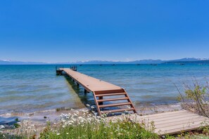A wooden pier extending into a clear lake with boats in the distance and mountains in the background. - Majestic Waters - Lakefront - TLUXP (Tahoe Vista)