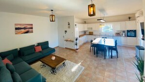 A modern living room with a green sofa, a wooden coffee table, and a painting on the wall. - Spacious T5, terrace, near center, private parking (Perpignan)
