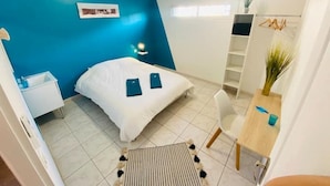 A bedroom with a bed, bedside tables, a desk, and a chair. - Spacious T5, terrace, near center, private parking (Perpignan)