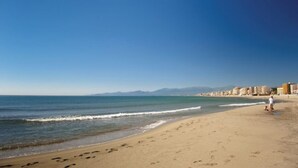 A beach with footprints, a person, and buildings in the background. - Spacious T5, terrace, near center, private parking (Perpignan)