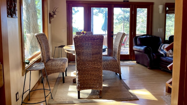 A cozy interior with wicker chairs, a leather sofa, and a dining table. - Explore. Rest. Restore. (Rimforest)