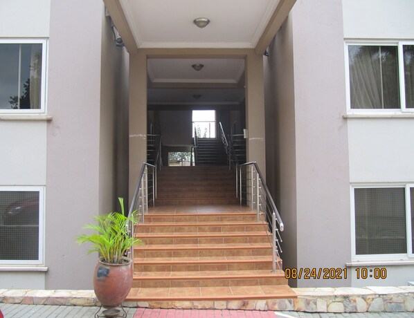 Ein Gebäudeeingang mit einer Treppe, die zu einer zweiten Etage führt.