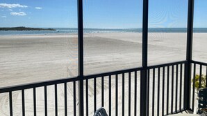 Een balkon met uitzicht op een strand en de oceaan.