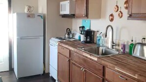 Una cucina con mobili in legno, un lavandino in acciaio inossidabile e un frigorifero bianco.