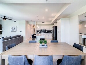 A modern kitchen with white cabinets, a black refrigerator, and a central island with bar stools.
