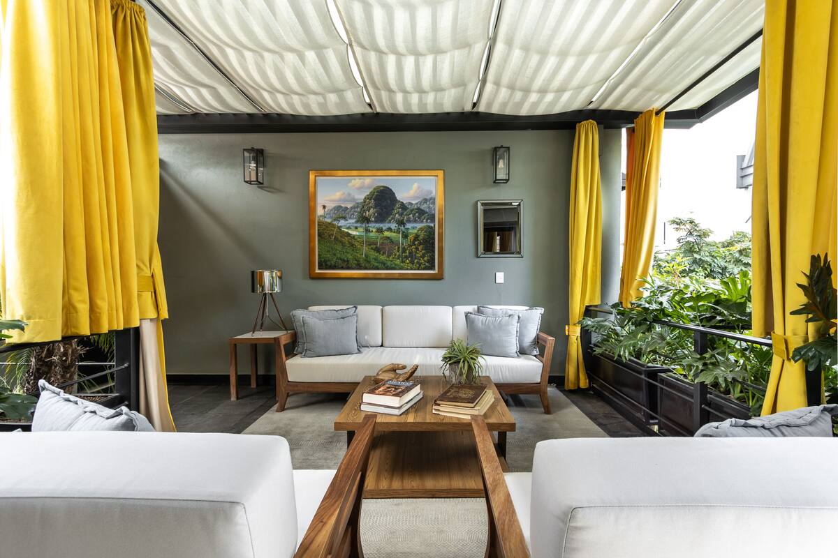 Uma sala de estar acolhedora com sofá, mesa de centro e cortinas amarelas.