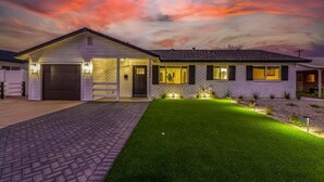 Une maison à deux étages avec un garage, une pelouse bien entretenue et une allée.