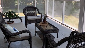 A covered porch with wicker furniture, a small table, and potted plants. - Spacious Home and Private Getaway (Fayette)
