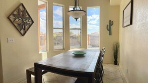 A dining area with a wooden table, chairs, and a chandelier.
