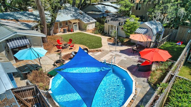 Un giardino sul retro con piscina, patio coperto e recinzione.