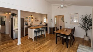 Una cocina moderna con una isla central, una mesa de comedor de madera y sillas.