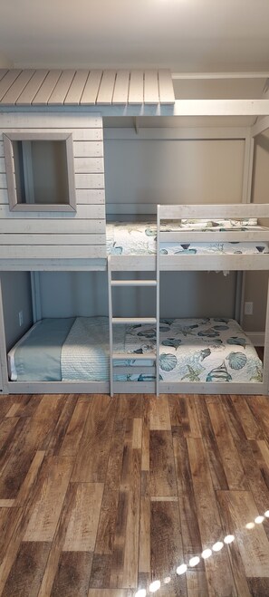 A bunk bed with a small window and a storage shelf.
