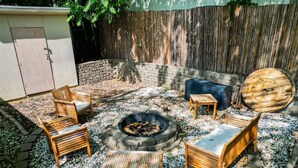 A backyard with a fire pit, wooden furniture, and a large wooden bowl. - Cozy 3Bed Home w/ Firepit By Zoo, Downtown & I/80❤ (Omaha)