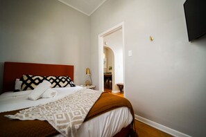 A bedroom with a large bed, a red headboard, and a patterned throw blanket. - Cozy 3Bed Home w/ Firepit By Zoo, Downtown & I/80❤ (Omaha)
