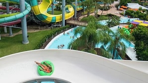Un parc aquatique doté de nombreux toboggans et de plusieurs piscines, le tout entouré de verdure.