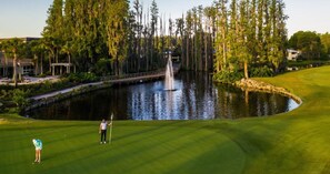 A golf course with a pond, trees, and a bridge. - Walk to dwnt/7min to beach/king bed/free parking (New Port Richey)