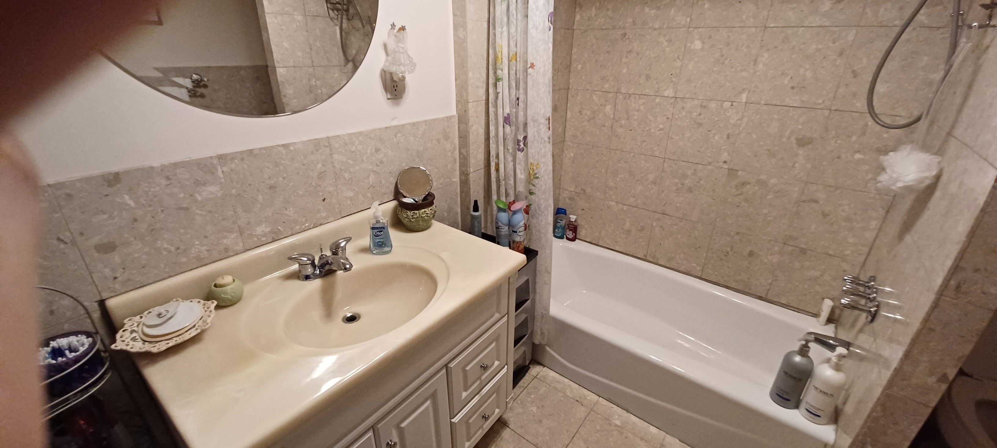 Ein Badezimmer mit Waschbecken, Spiegel und Badewanne.
