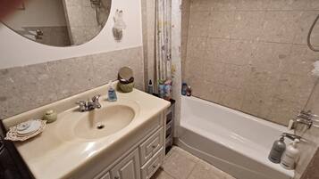 Ein Badezimmer mit Waschbecken, Spiegel und Badewanne.