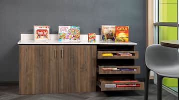 A reception desk with board games and a bookshelf.
