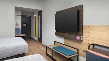 A hotel room with two beds, a TV, a desk, and a bench.