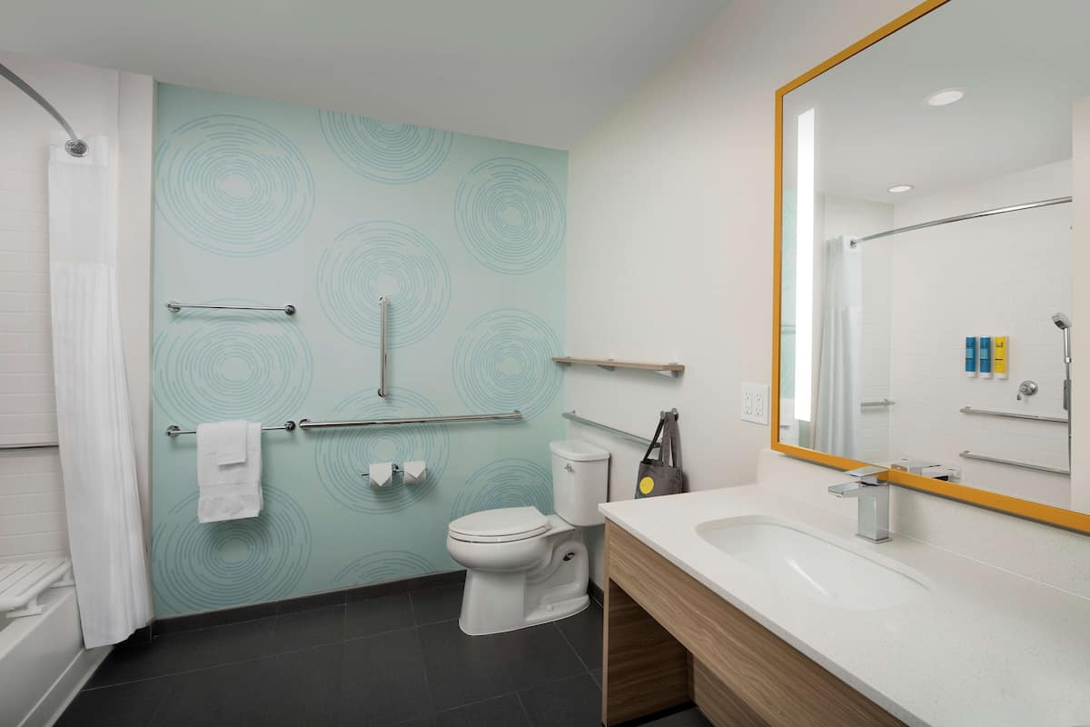 Een moderne badkamer met toilet, wastafel en douche.