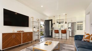 Un salon moderne avec un canapé, une table basse et un téléviseur fixé au mur.