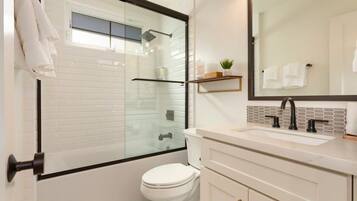 Bathtub, hair dryer, towels, shampoo