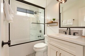 Bathtub, hair dryer, towels, shampoo