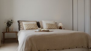 A neatly arranged bedroom with a bed, bedside table, lamp, and a small plant. - Casa Moci (Playa Blanca)