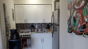 A compact kitchen with white cabinets, a gas stove, a refrigerator, and a coffee maker on a portable stand. - ☼☼ Walk 2 the Beach ~♡♡~ Gorgeous 1 BR ☼☼ (West Palm Beach)