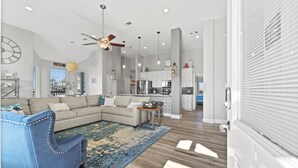 A modern living room with a sectional sofa, a blue armchair, and a wooden coffee table.