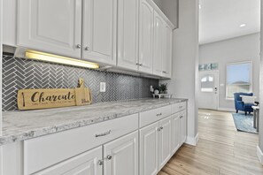 Enjoy a charcuterie experience in this well-equipped kitchen with an oven and range hood.