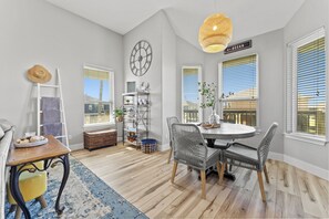 Enjoy a bright and airy space with a round dining table, comfortable chairs, and a stunning ocean view.