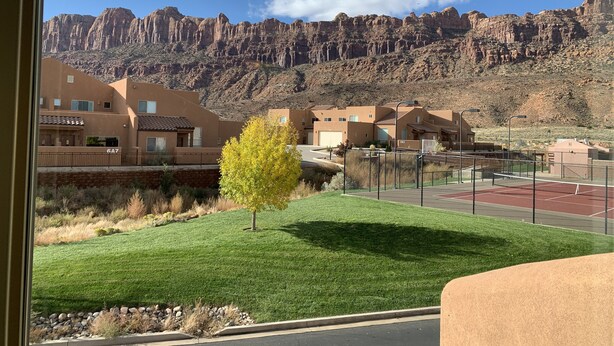 A residential area with modern buildings, a well-maintained lawn, and a mountain backdrop. - Beautiful Moab Townhome (moab)