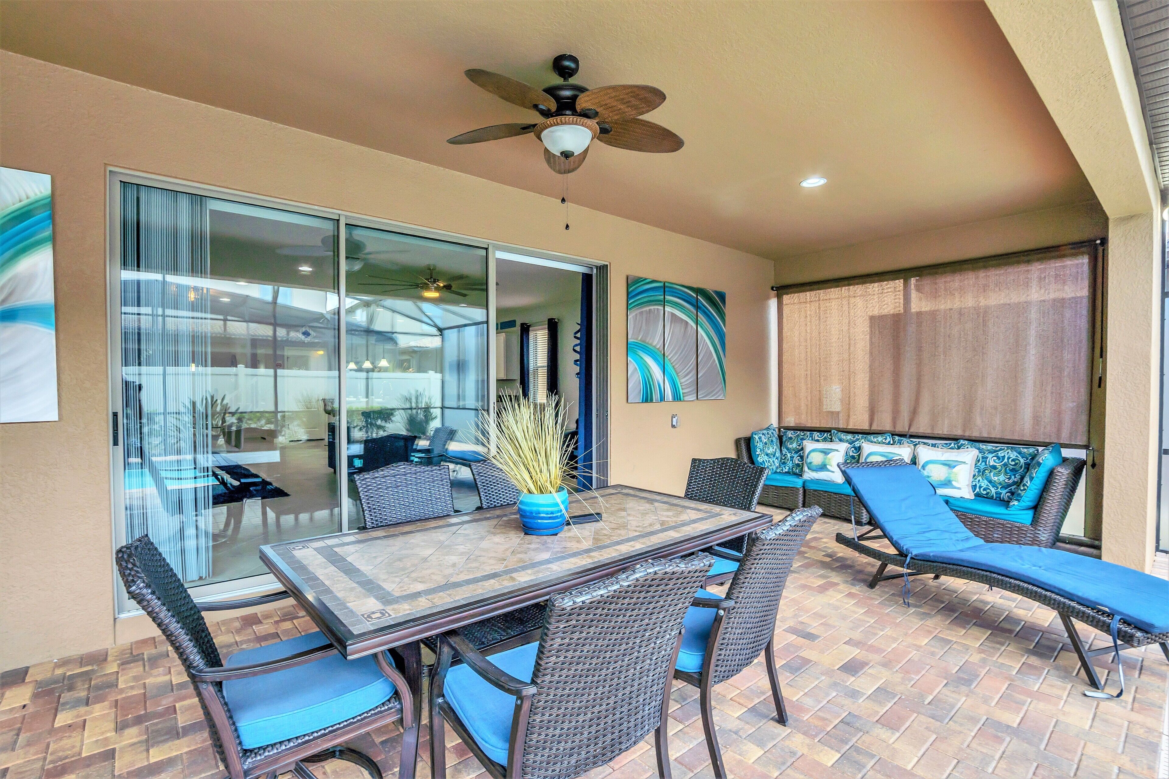 A patio with a glass door leading to an outdoor area, a ceiling fan, and a dining table with chairs.