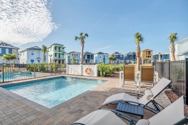 A pool area with lounge chairs, a lifebuoy, and a brick pathway. - Margaritaville Cottage, Private Pool, Near Disney! (Kissimmee)