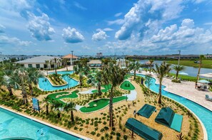A resort with a swimming pool, a golf course, and a view of the water.